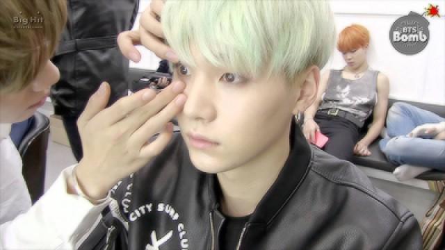 SUGA is trying to wear contact lenses.